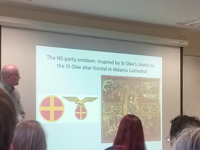 Øystein Ekroll showing a slide from his talk about the NS party and the use of St. Olav's shield as the party's emblem. Photo by Medievalists.net